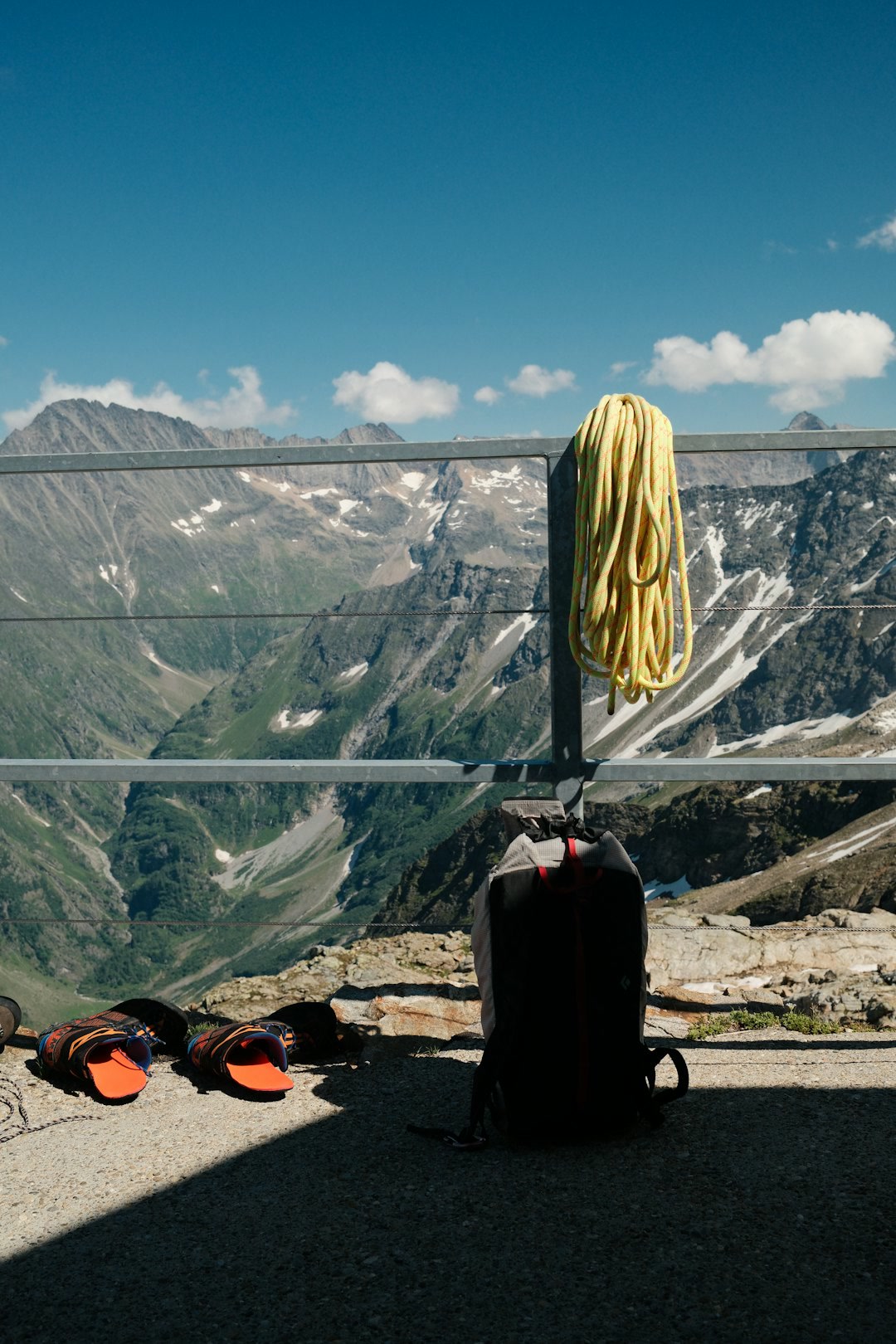 A fully packed backpacking pack standing upright on a trail overlook with mountains in the background