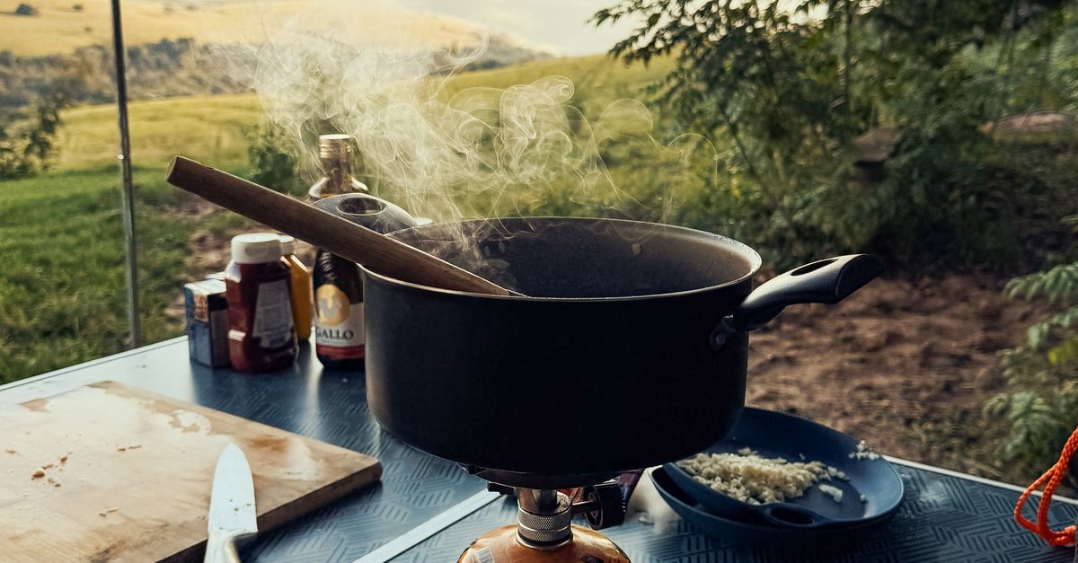 Camp cooking setup with pots and pans on an outdoor stove