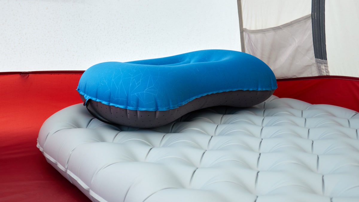 Inflated sleeping pad inside a tent with sleeping bag laid out at sunrise