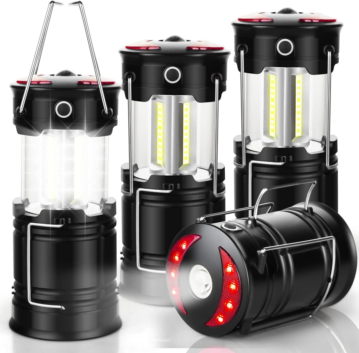 Multiple camping lanterns arranged on a wooden picnic table at dusk