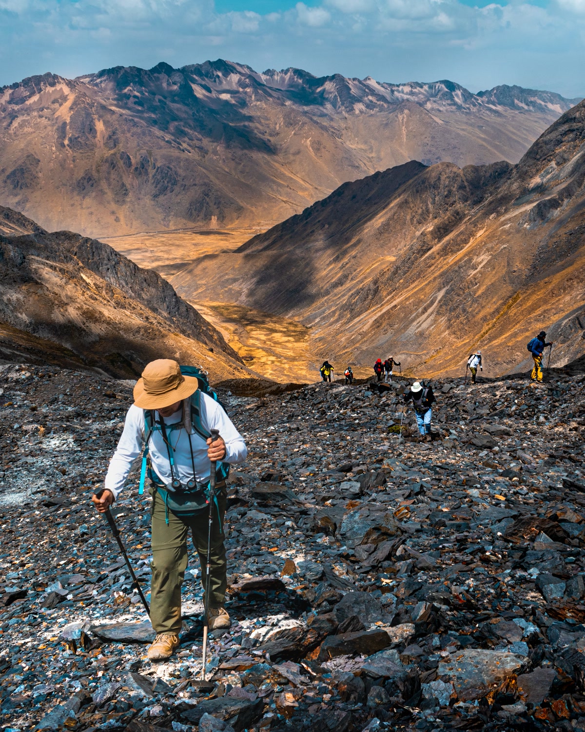 Trekking poles on a rocky mountain trail with scenic valley view
