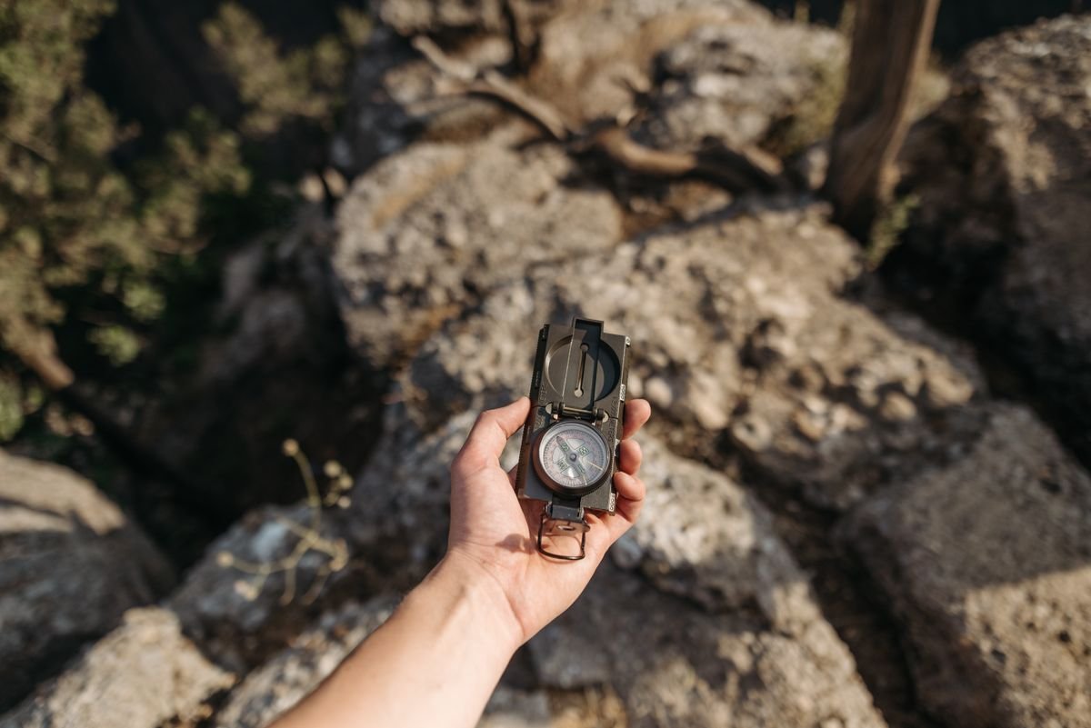 Compass and topographic map on a rock at a trail junction in the mountains