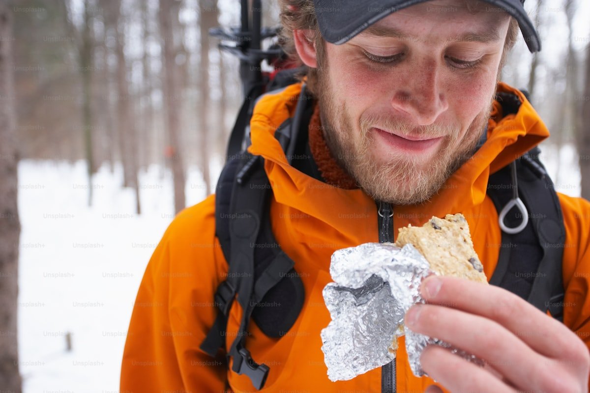Hiking backpack with emergency blanket packed on a mountain trail in overcast weather