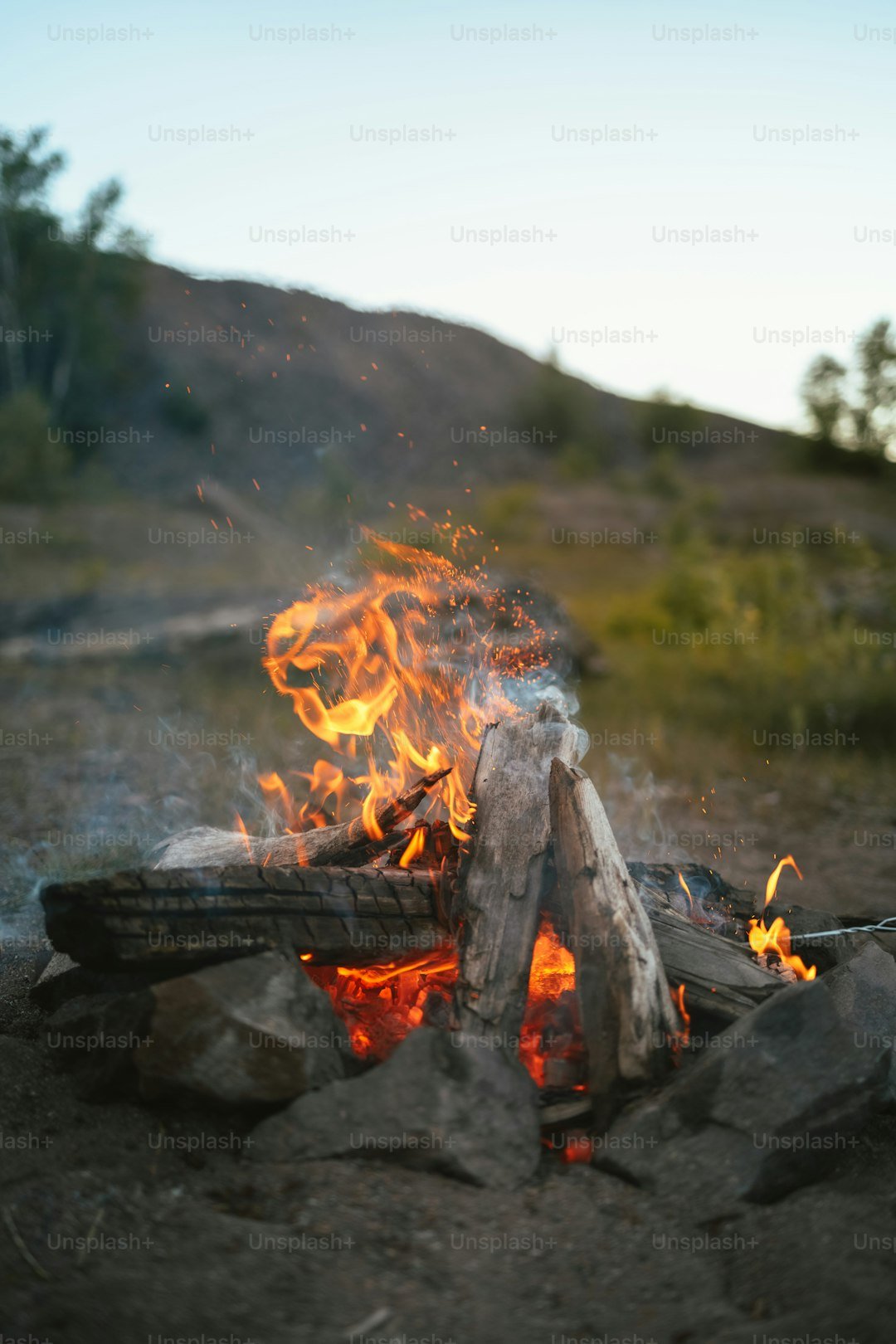 Campfire burning steadily in a fire ring at a backcountry campsite