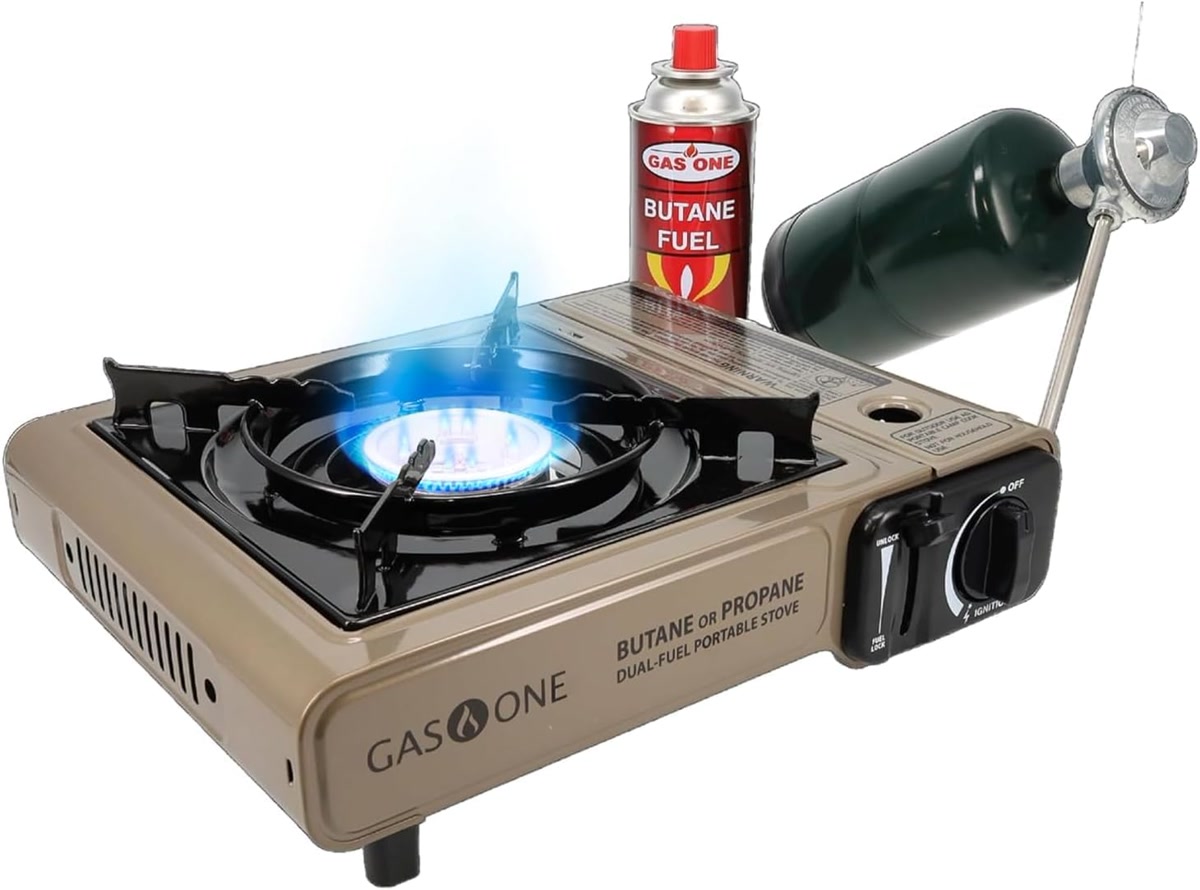 Gas One GS-3400P single burner stove with a small pot on it, sitting on a rocky campsite ledge, show
