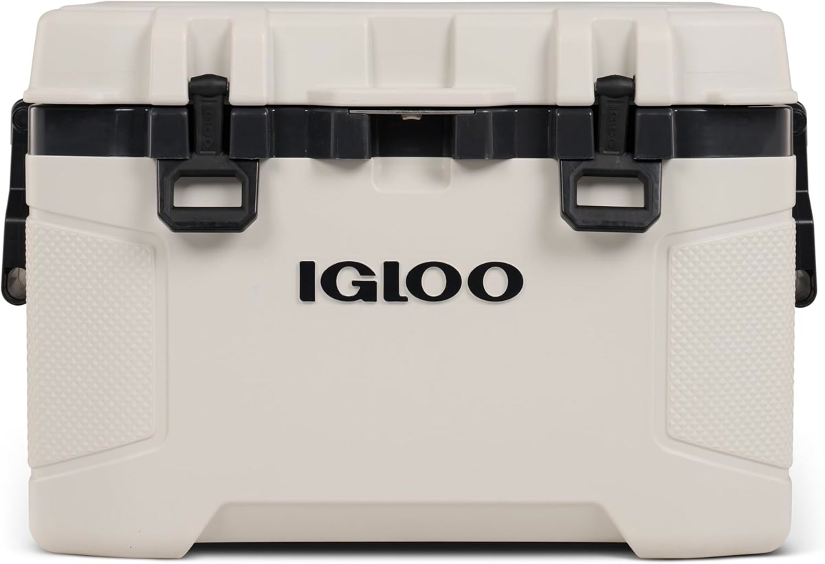 Igloo Trailmate cooler on a dirt trail with large all-terrain wheels visible, camping scene in backg
