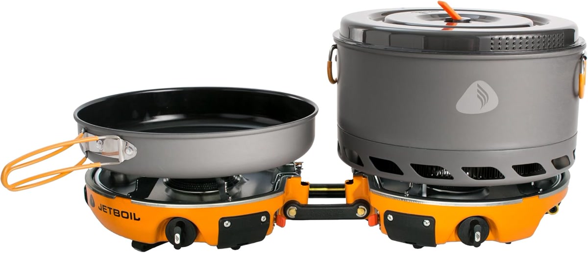 Jetboil Genesis Basecamp System opened up showing the nested pot, fry pan, and stove, set on a rock